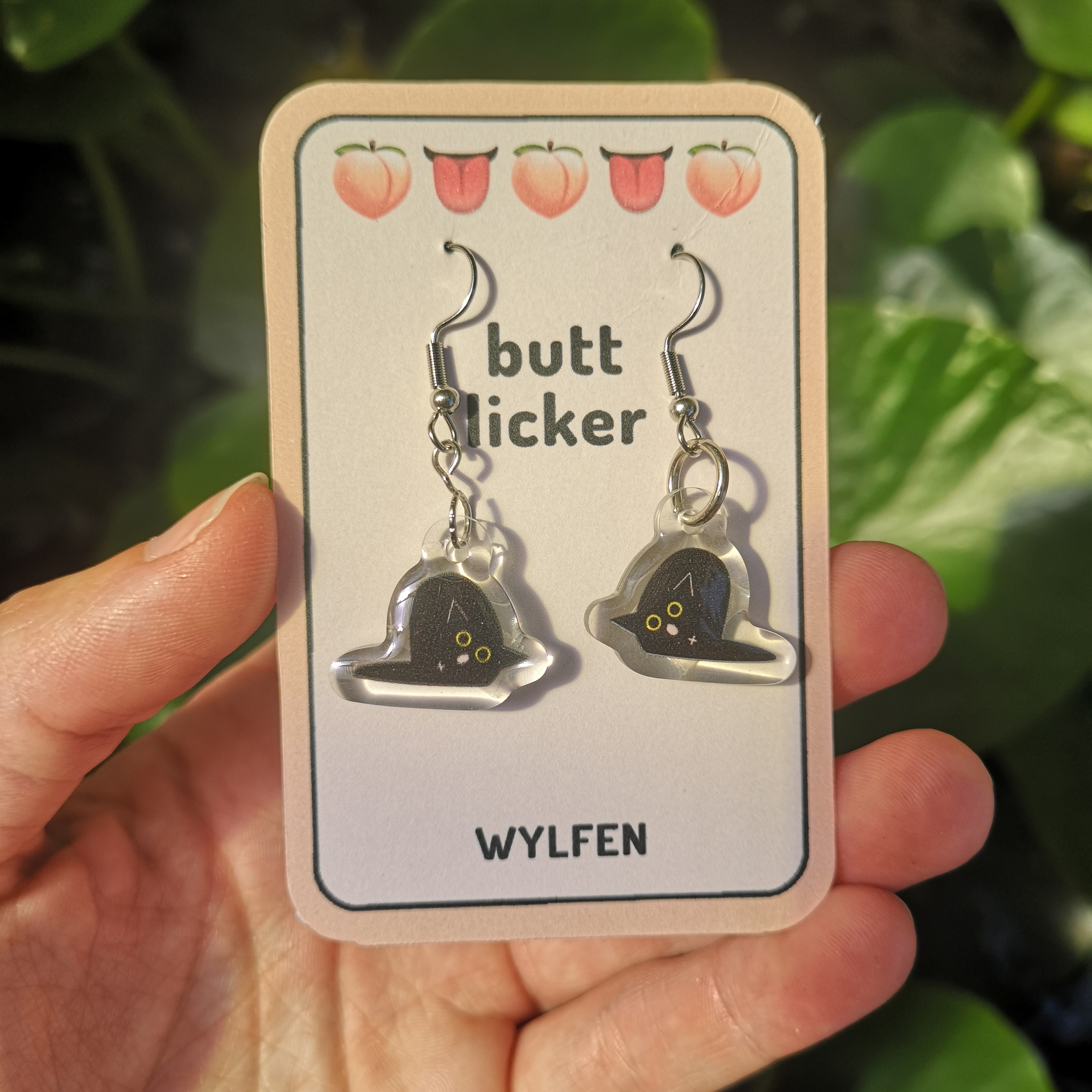 Funny earrings with a cat licking its own butt